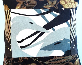 May include: A square throw pillow featuring a central rectangular panel with a light blue and white graphic illustration of two bird heads. The surrounding fabric is black with an intricate gold embroidered floral and leaf pattern throughout.