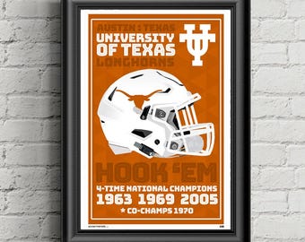 May include: Framed poster featuring a white football helmet with the University of Texas Longhorns logo. The poster has an orange background with text that reads "HOOK 'EM" and lists championship years.