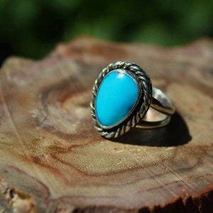 May include: A silver ring with a turquoise stone set in a twisted silver band.