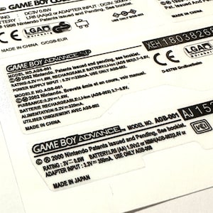 May include: Close-up of a white Game Boy Advance SP label with black text. The label includes the model number AGS-001, the rating, power supply input, and battery information. The label also includes the text "Made in China".