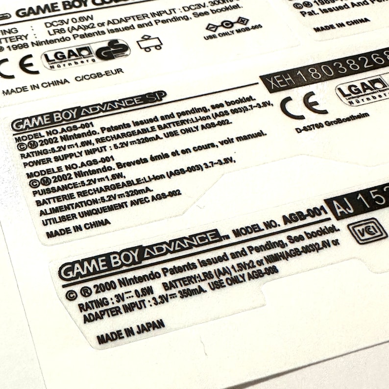 May include: Close-up of a white Game Boy Advance SP label with black text. The label includes the model number AGS-001, the rating, power supply input, and battery information. The label also includes the text "Made in China".