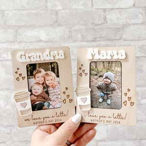 Puede incluir: Dos marcos de fotos de madera con un dise&ntilde;o de taza de caf&eacute; y las palabras "Grandma" y "Mama" en ellos. Cada marco tiene una foto de ni&ntilde;os y el texto "we love you a latte!" y "i love you a latte!" con la fecha "Mother's Day 2024" debajo.