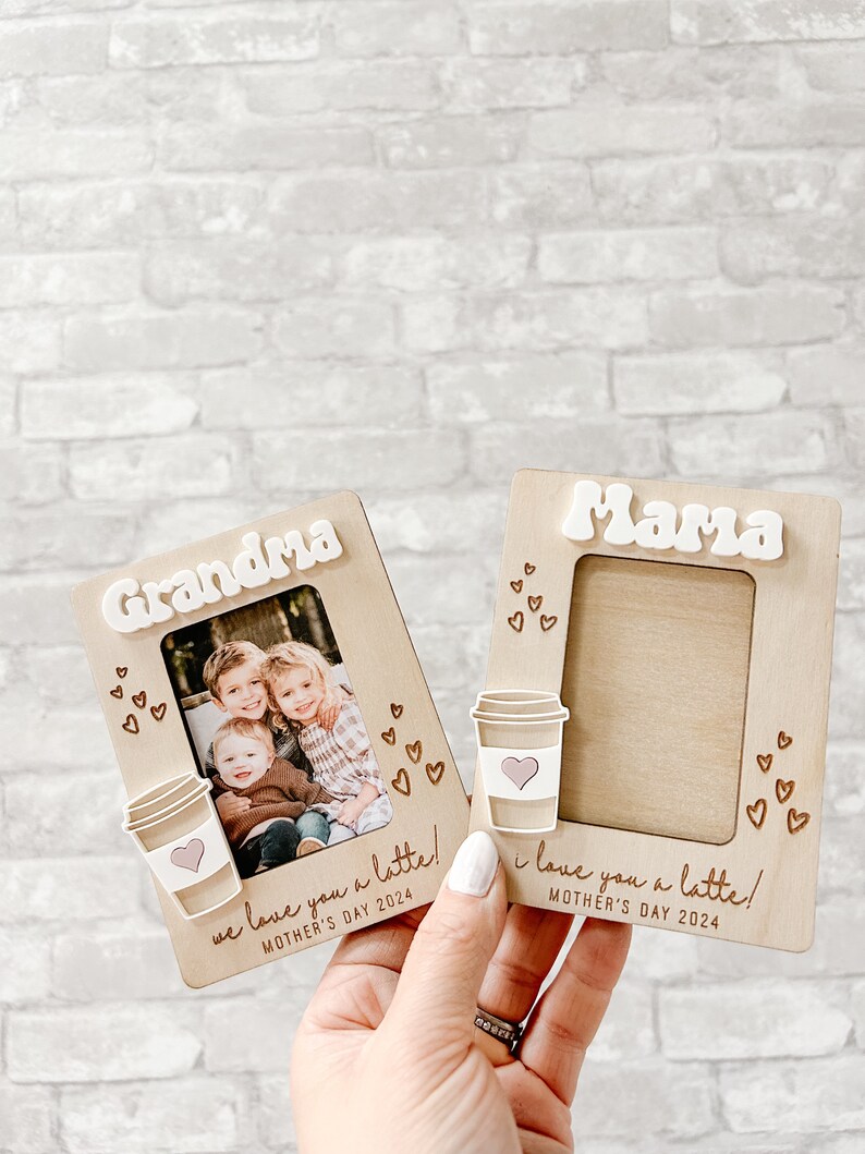Puede incluir: Dos marcos de fotos de madera con un dise&ntilde;o de taza de caf&eacute; y el texto "we love you a latte!" y "I love you a latte!"  Un marco tiene una foto de tres ni&ntilde;os. Ambos marcos tienen el texto "Mother's Day 2024".