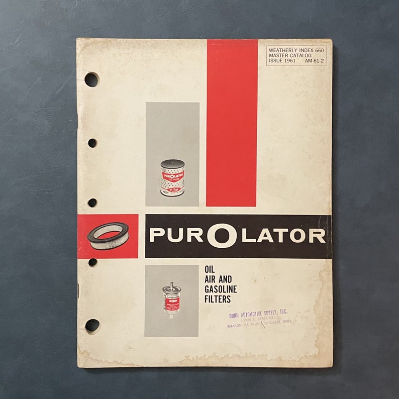 Pu&ograve; includere: Una copertina di catalogo vintage per filtri olio, aria e benzina Purolator. La copertina presenta il logo Purolator in bianco e nero su sfondo rosso. Il testo "Weatherly Index 660 Master Catalog Issue 1961 AM-61-2" &egrave; stampato in nero nella parte superiore della pagina.