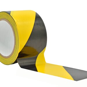 May include: A roll of yellow and black striped caution tape. The tape is partially unrolled, showing the black and yellow stripes.