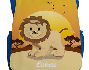 Könnte beinhalten: Ein blauer Rucksack mit einem gelben und braunen Löwenmotiv. Der Löwe lächelt und hat eine braune Mähne. Der Rucksack hat den Namen "Lukas" auf der Vorderseite aufgedruckt.