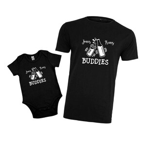 May include: Black and white matching baby onesie and t-shirt set with a graphic of two baby bottles clinking, the text "Jonas Franz Buddies" and a small graphic of a milk drop.