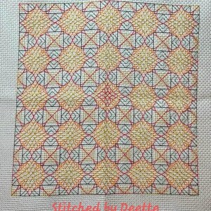 May include: A cross-stitch pattern with a geometric design featuring a repeating pattern of circles, squares, and triangles in shades of yellow, orange, red, and black. The pattern is stitched on a white Aida cloth. The text "Stitched by DeeEtte" is visible at the bottom of the image.