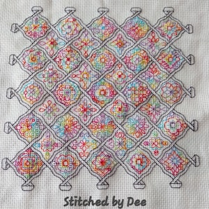 Könnte beinhalten: Ein farbenfrohes Kreuzstichmuster mit verschiedenen geometrischen Formen und Designs. Das Muster ist auf einem weißen Stoff gestickt und mit einem schwarzen Rand umrahmt. Der Text "Stitched by Dee" steht unter dem Muster.