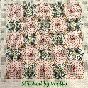 Może przedstawiać: Wzór haftu krzyżykowego z powtarzającym się wzorem czerwonych i białych spiral w czarno-zielonym wzorze geometrycznym. Wzór jest wyszyty na białej tkaninie Aida, a tekst "Stitched by Deette" znajduje się na dole obrazu.