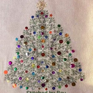 Peut inclure: Un sapin de Noël brodé en vert avec une étoile dorée au sommet, décoré de paillettes colorées et d'étoiles dorées. Le texte "Stitched by Bev" est en bas de l'image.