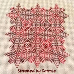 May include: A close-up of a red and brown cross-stitch pattern with a repeating geometric design. The pattern is stitched on a white fabric and the text "Stitched by Connie" is at the bottom of the image.