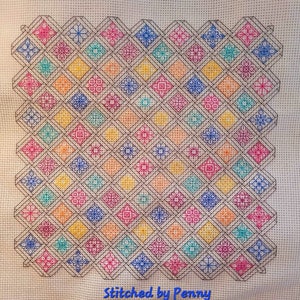 May include: A colorful cross-stitch pattern with a variety of small floral designs in a diamond pattern. The background is a light beige fabric. The text "Stitched by Penny" is at the bottom of the image.