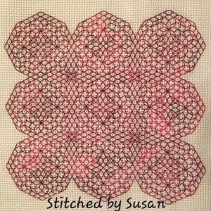 May include: A close-up of a red and black geometric cross-stitch pattern. The pattern is made up of repeating hexagons and stars. The text "Stitched by Susan" is visible at the bottom of the image.