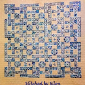 Könnte beinhalten: Ein blaues und weißes Kreuzstichmuster mit geometrischem Design. Das Muster ist auf einem hellorangenen Stoff gestickt. Der Text "Stitched by Ellen" befindet sich am unteren Rand des Bildes.