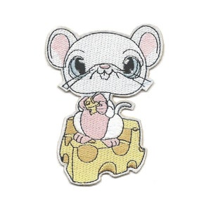 Pode incluir: Rato branco bordado sentado em um bloco de queijo amarelo, segurando um pequeno pedaço de queijo em suas patas.
