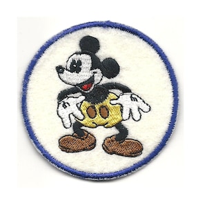 May include: A white embroidered patch with a blue border featuring Mickey Mouse in a yellow and black outfit.