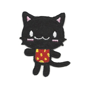 May include: Black embroidered iron-on patch of a cartoon cat wearing a red and yellow polka dot shirt.