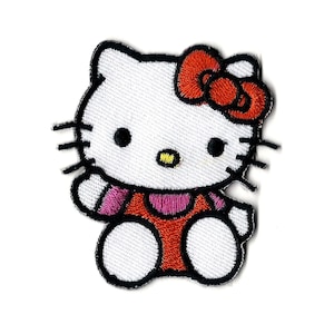 May include: Embroidered patch of Hello Kitty. The patch shows the character with a white face, black eyes and whiskers, a red bow, and a red and pink outfit. The patch is outlined in black.