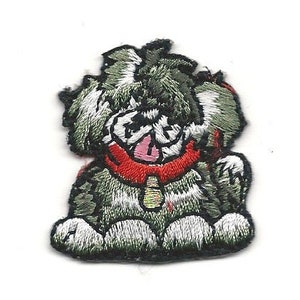 May include: Embroidered patch of a cartoon dog with a red collar and a small bell. The dog has gray and white fur, a pink tongue, and is sitting down. The patch is on a white background.
