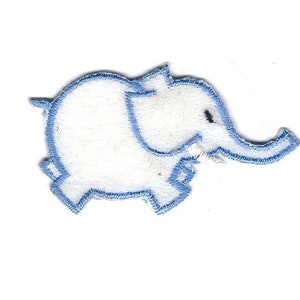 Könnte beinhalten: Ein weißer Filz-Elefanten-Applikator mit blauen Nähten. Der Elefant blickt nach rechts und hat ein kleines schwarzes Auge.