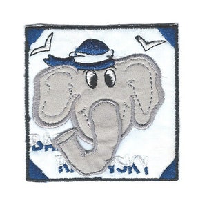 Puede incluir: Un parche bordado azul y blanco con un elefante de dibujos animados que lleva un sombrero azul. El elefante mira hacia la derecha y tiene una trompa enroscada. El parche tiene un fondo blanco con bordes azules y el texto "BAILEY" es visible en la parte inferior.