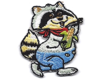 Puede incluir: Un parche bordado de un mapache de dibujos animados que lleva un mono azul y una bandana roja, sosteniendo una mazorca de maíz.