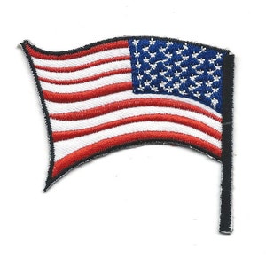 Può includere: Un piccolo patch ricamato della bandiera americana con strisce rosse e bianche e stelle blu. La bandiera sventola al vento ed è attaccata a un palo nero.