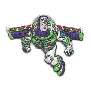 May include: An embroidered patch of Buzz Lightyear from the Toy Story franchise. Buzz is wearing his space ranger suit and has his wings out. He is flying through the air with a determined expression on his face.