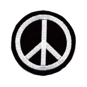 May include: A black and white peace sign embroidered patch. The peace sign is white and the background is black.