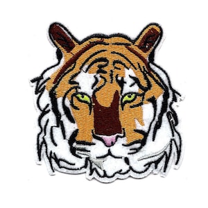May include: Embroidered patch of a tiger's face with brown, orange, and white fur. The tiger has green eyes and a pink nose.