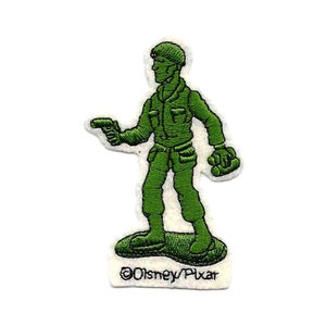 May include: Green plastic toy soldier with a gun and a backpack, standing on a green base. The soldier is wearing a green helmet. The text "©Disney/Pixar" is printed below the soldier.