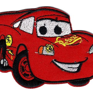 May include: Embroidered patch of a smiling red race car with black tyres and white headlights. The car has the number 95 and the word "Rust-eze" in yellow. A fun, colourful design for children.