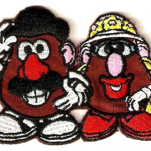Puede incluir: Dos parches de fieltro bordados de Mr. y Mrs. Potato Head. Mr. Potato Head lleva un sombrero negro y tiene un bigote marrón. Mrs. Potato Head lleva un sombrero amarillo y tiene una nariz rosa.