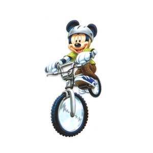 以下が含まれることがあります： 銀色の BMX バイクに青いタイヤと白いタイヤを履いて乗っているミッキーマウスの漫画のイラスト。ミッキーは緑のシャツ、茶色のズボン、白いヘルメットを着用しています。