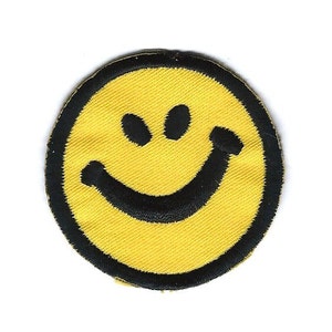 May include: A yellow smiley face patch with a black outline. The smiley face has two black eyes and a wide black smile.