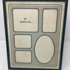 May include: A black picture frame with a green mat and five openings for photos. The frame has a crown and the word "Hallmark" printed on it.
