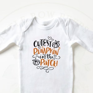 Könnte beinhalten: Weißer langärmliger Baby-Strampler mit schwarzem Text, der "Cutest Pumpkin in the Patch" lautet, mit einer kleinen orangefarbenen Kürbisgrafik.
