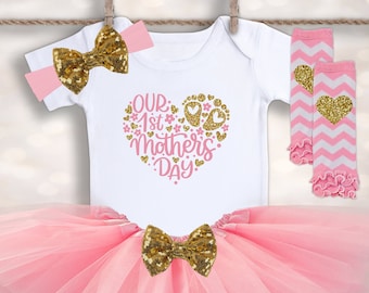 Könnte beinhalten: Rosa-goldenes Baby-Mädchen-Outfit mit einem Tüllrock, Beinstulpen, einem Stirnband und einem weißen Strampler mit der Aufschrift "Unser 1. Muttertag".