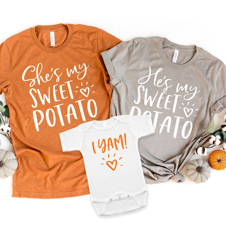 Puede incluir: Tres camisetas blancas con texto naranja. La camiseta m&aacute;s grande dice "She's my sweet potato" con un peque&ntilde;o coraz&oacute;n. La camiseta mediana dice "He's my sweet potato" con un peque&ntilde;o coraz&oacute;n. La camiseta m&aacute;s peque&ntilde;a dice "I yam!" con un peque&ntilde;o coraz&oacute;n.