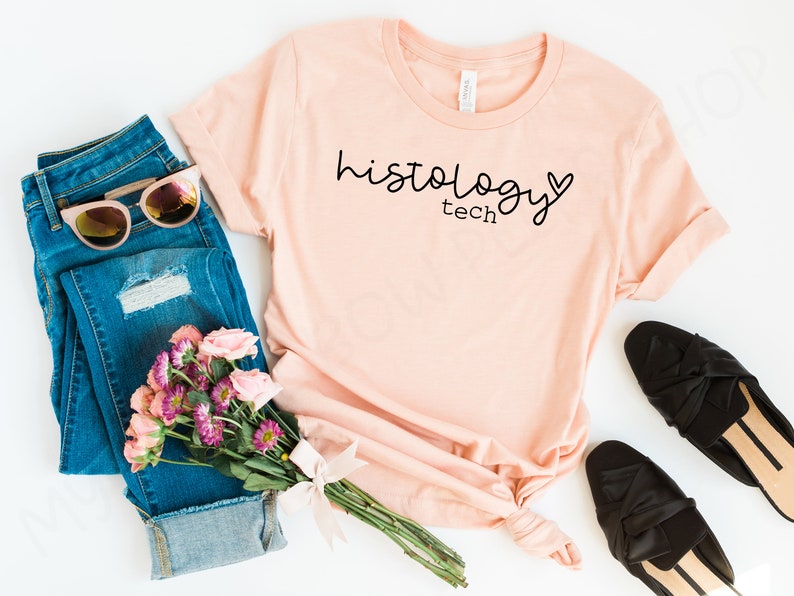 May include: A peach-colored t-shirt with the text "histology tech" and a small heart graphic printed on the front.