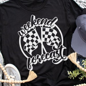 May include: Black t-shirt with a white graphic design of two chequered flags crossed with the text "weekend forecast" in a white cursive font.