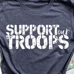 May include: A navy blue t-shirt with a white distressed graphic that says "Support our Troops".