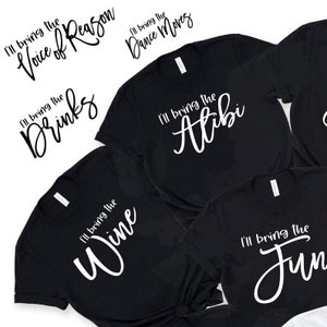 May include: Five black t-shirts with white text. Each shirt has a different phrase: "I'll bring the Voice of Reason", "I'll bring the Drinks", "I'll bring the Wine", "I'll bring the Dance Moves", and "I'll bring the Alibi".
