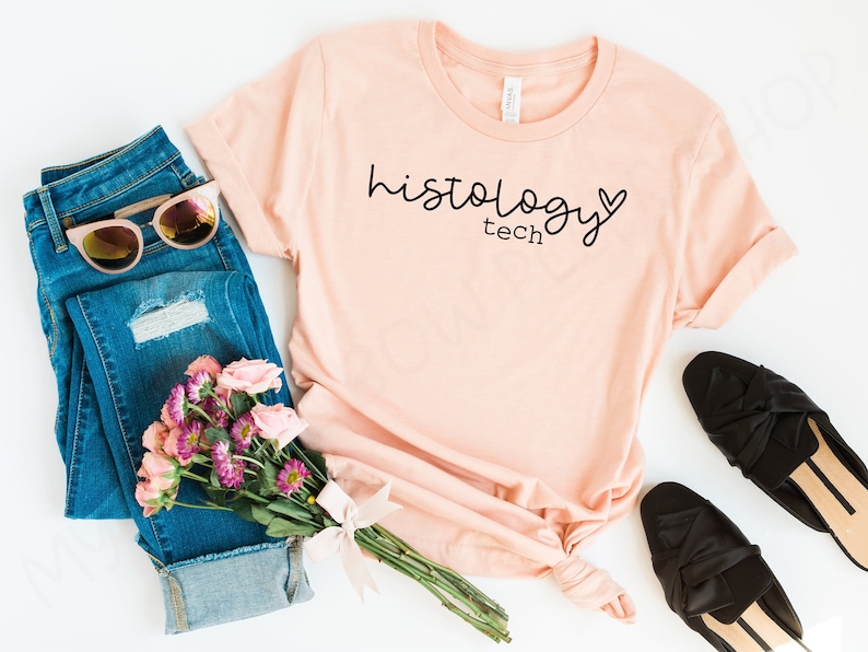 May include: A peach-colored t-shirt with the text "histology tech" and a small heart graphic printed on the front.