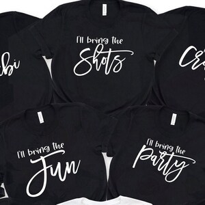 May include: Five black t-shirts with white text. The shirts say "I'll bring the shots", "I'll bring the fun", "I'll bring the party", "Crib", and "bi".
