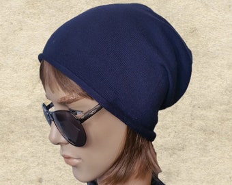 May include: A dark blue beanie hat made of knitted fabric. The hat is folded down at the brim.