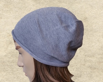 May include: A grey beanie hat made of a soft, knitted fabric. The hat is folded down at the brim, creating a slouchy look.