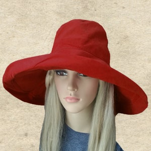 Puede incluir: Un sombrero de sol de ala ancha en un color rojo vibrante. El sombrero tiene un ala grande y ca&iacute;da que proporciona una amplia sombra. El sombrero est&aacute; hecho de una tela suave y ligera.