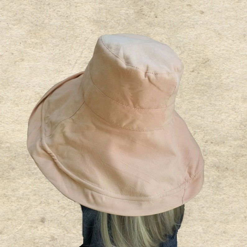Puede incluir: Un sombrero de ala ancha de color rosa p&aacute;lido. El sombrero est&aacute; hecho de una tela suave y ligera y tiene un dise&ntilde;o simple y cl&aacute;sico.